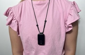 Person in pink shirt wearing black MGMini necklace