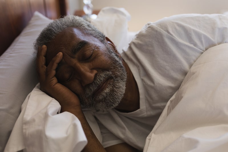 older adult man sleeping in bed