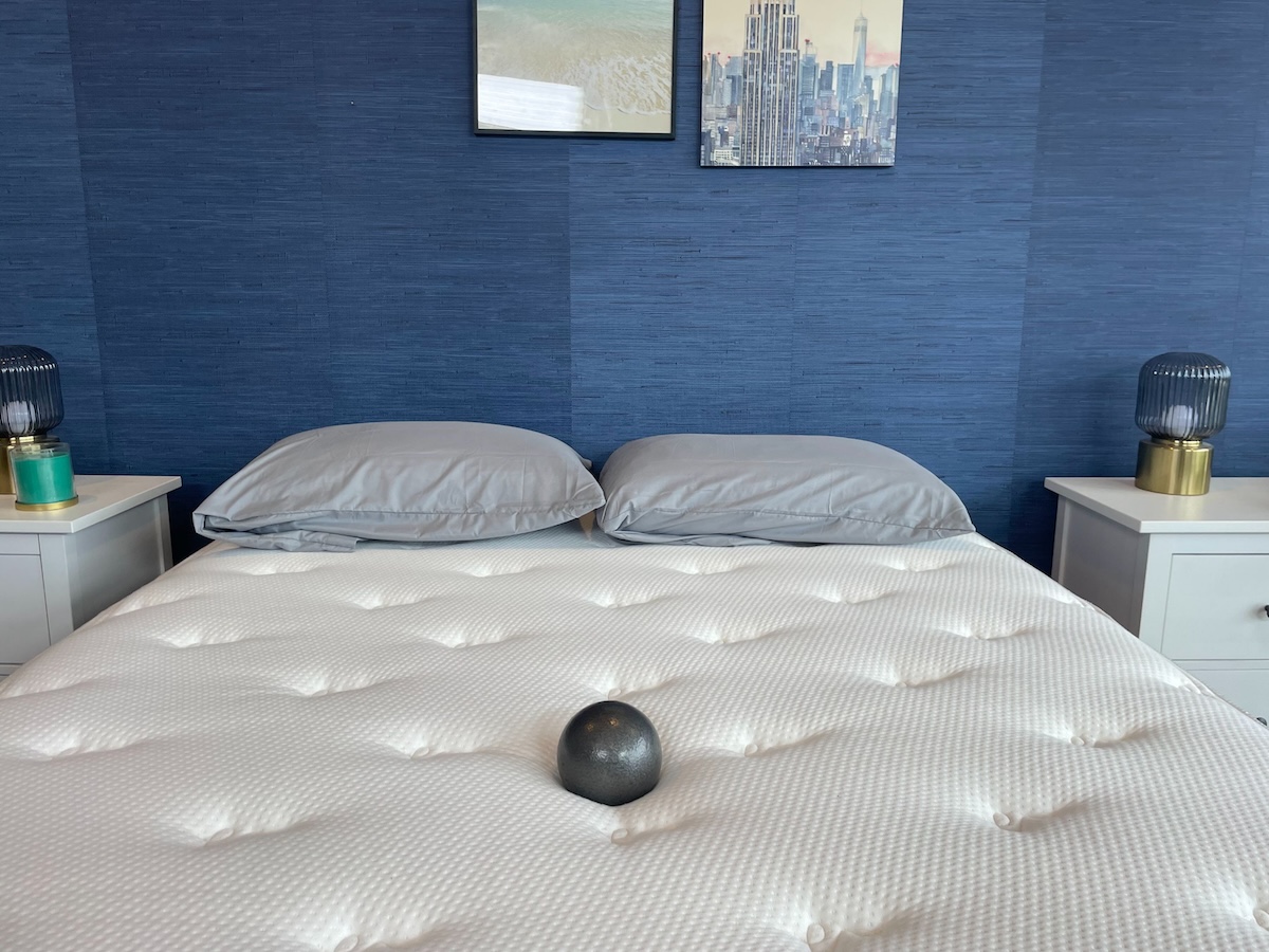  A 10-pound steel ball resting on a Brooklyn Bedding Signature Hybrid mattress.
