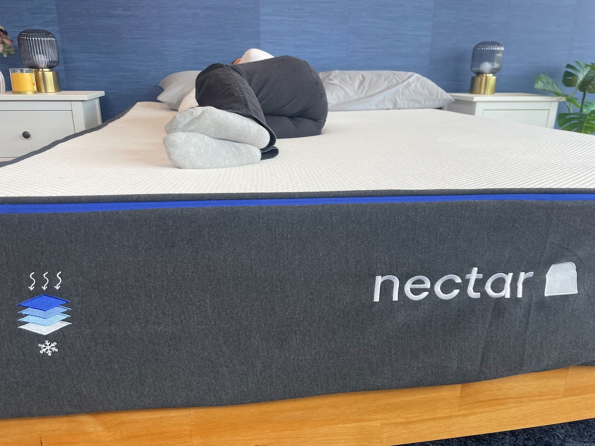 A tester lying on their side on the Nectar Memory Foam mattress. 

