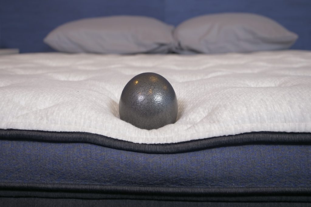 A 10-pound ball rests on the edge of the Helix Midnight Luxe to test edge support.