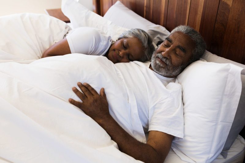 Older couple cuddled in bed together