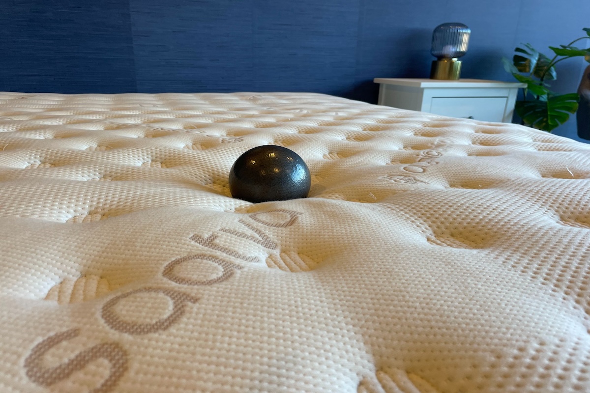 Ten-pound ball sitting on a Saatva Classic mattress to demonstrate mattress firmness and sinkage