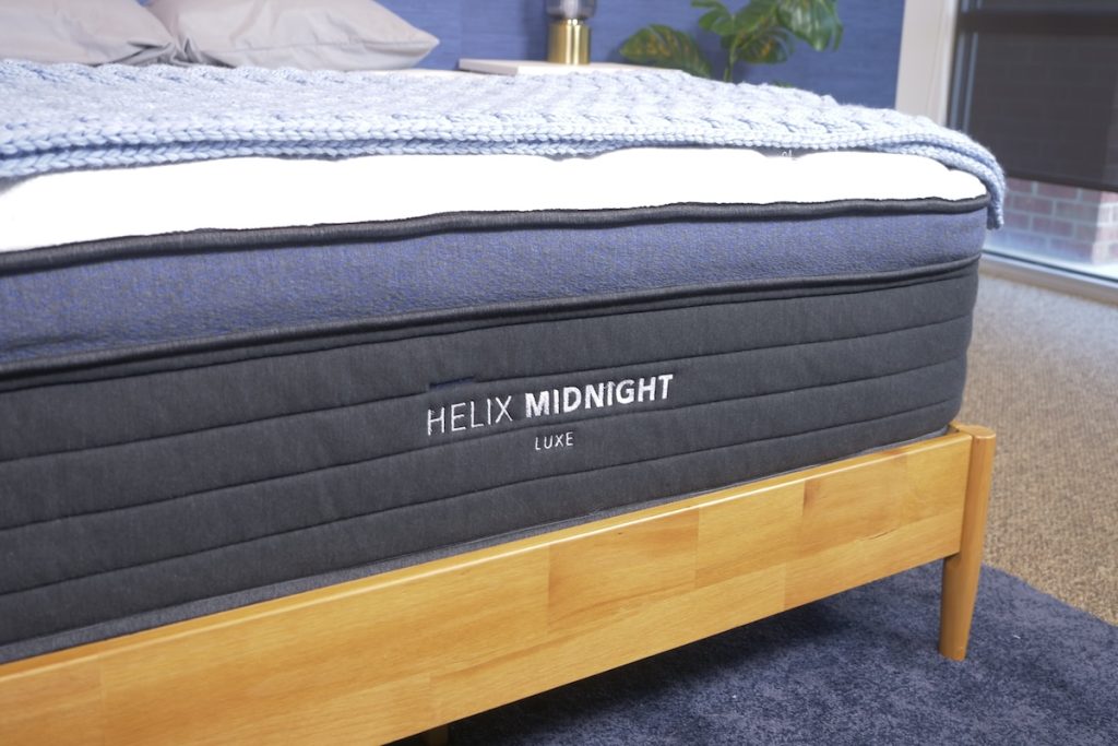 The Helix Midnight Luxe on a wooden bed frame