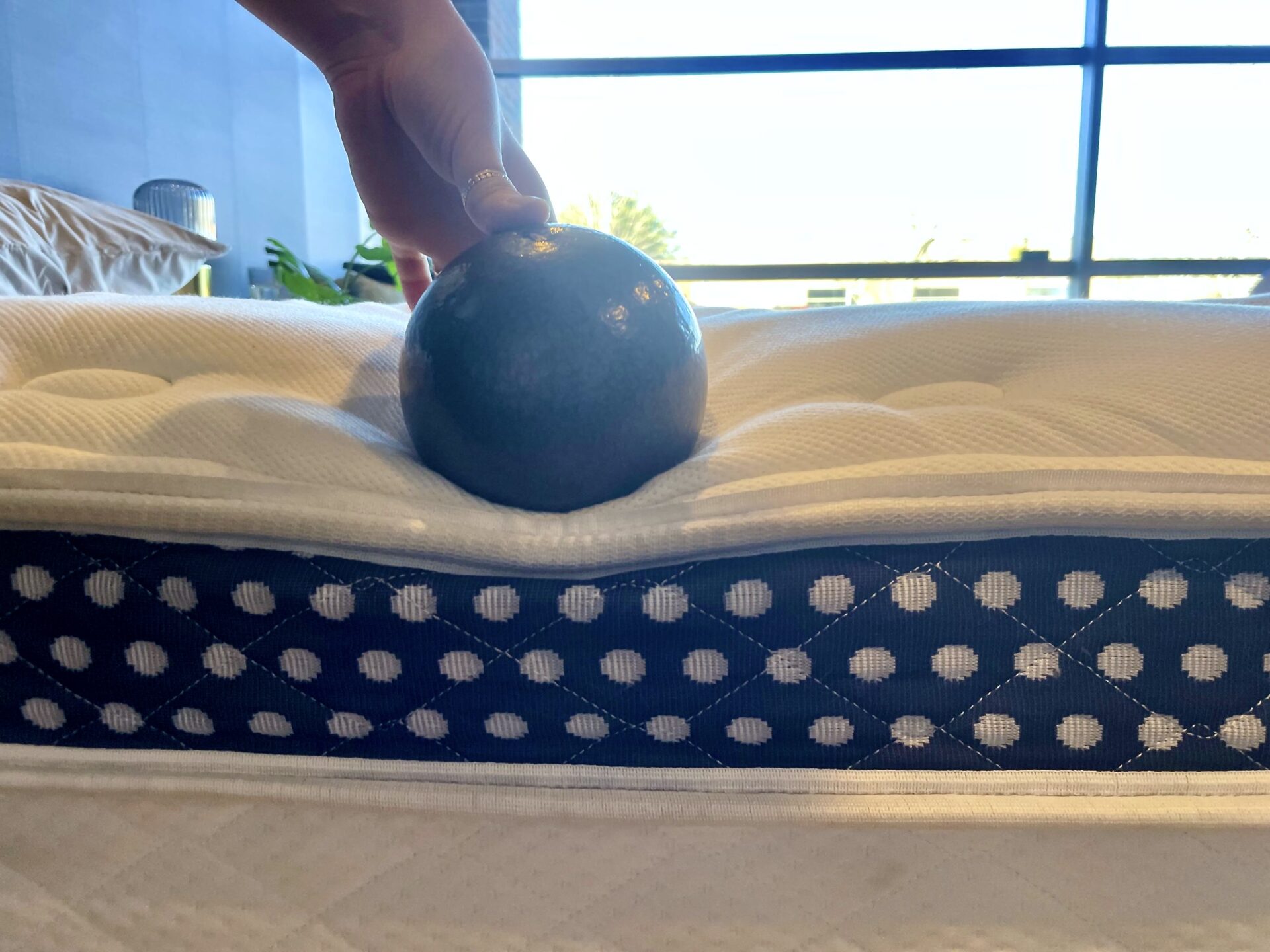Weighted ball being used to test the edge firmness of a WinkBed mattress