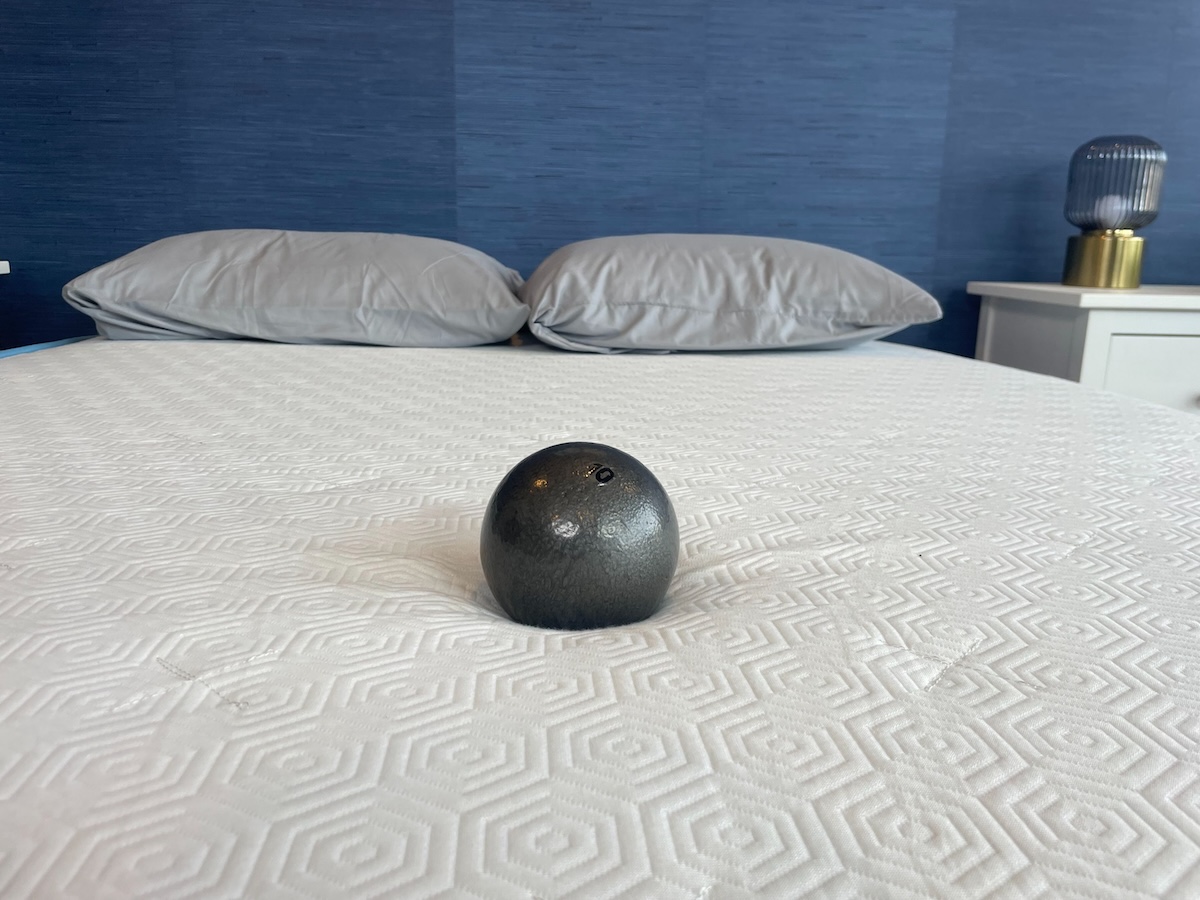 Bear Original mattress with weighted ball lightly sinking into the mattress to demonstrate the firmness level