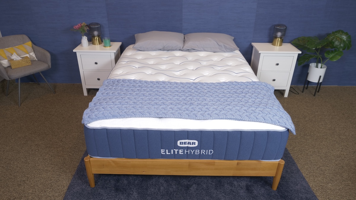  Bear Elite Hybrid mattress with a blue knitted blanket and pillows.