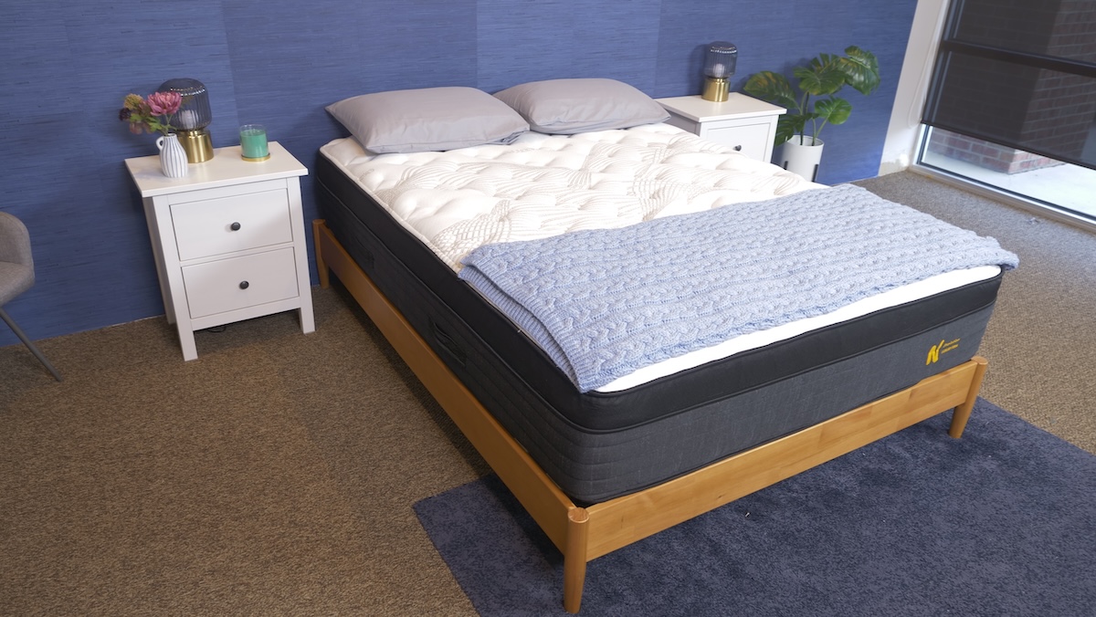  Black, gray, and white Nolah Evolution mattress with a blue knitted blanket and two pillows