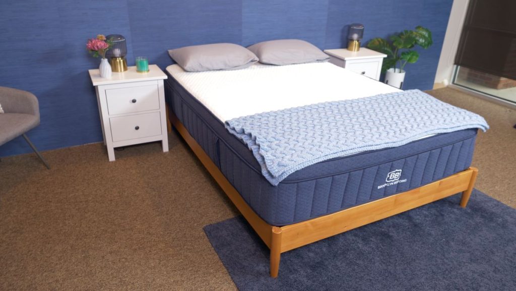 Brooklyn Bedding Aurora Luxe on a wooden bed frame with a blue blanket.