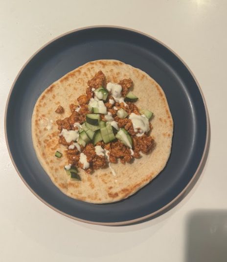 Cooked Mediterranean chicken pitzas with marinated cucumbers and sour cream on a plate