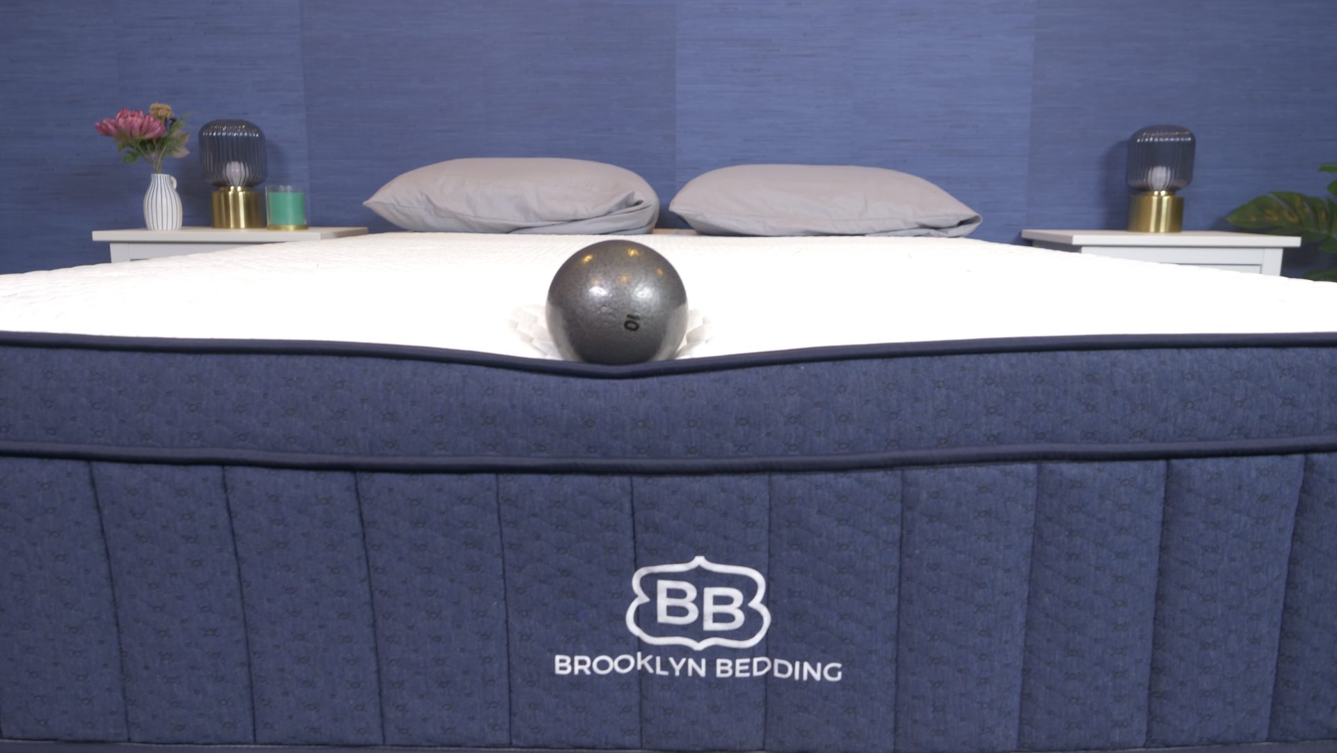 Our tester evaluating the edge support of the Brooklyn Bedding Aurora Luxe with a bowling ball.