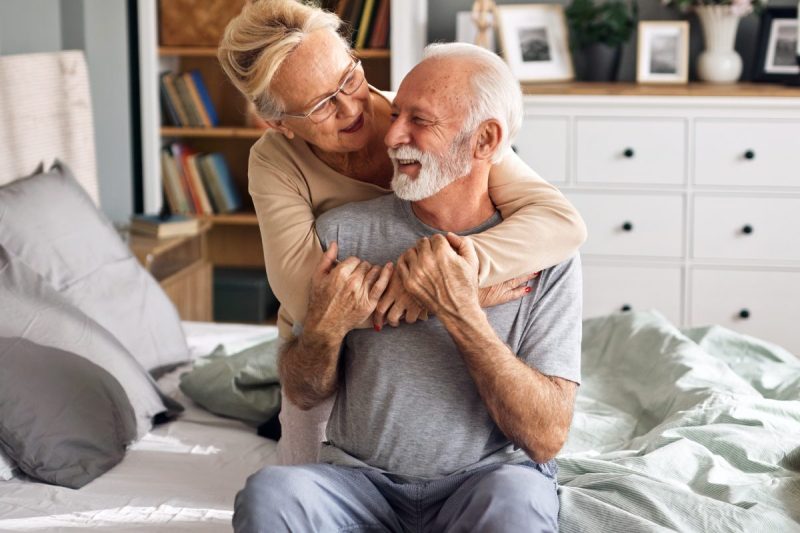 happy man and woman hugging in bed