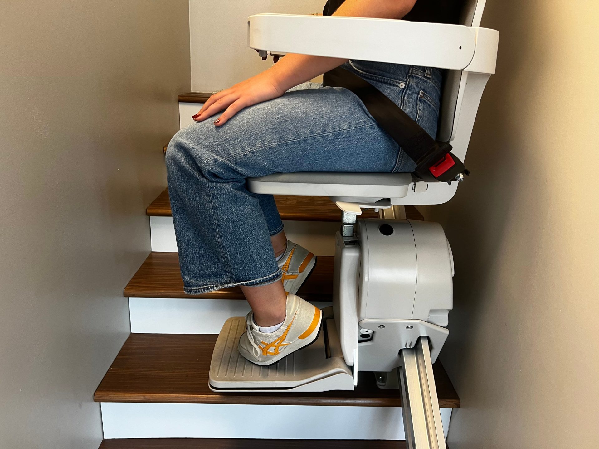 One of our testers sits in the Elan stair lift as it goes up a flight of stairs.