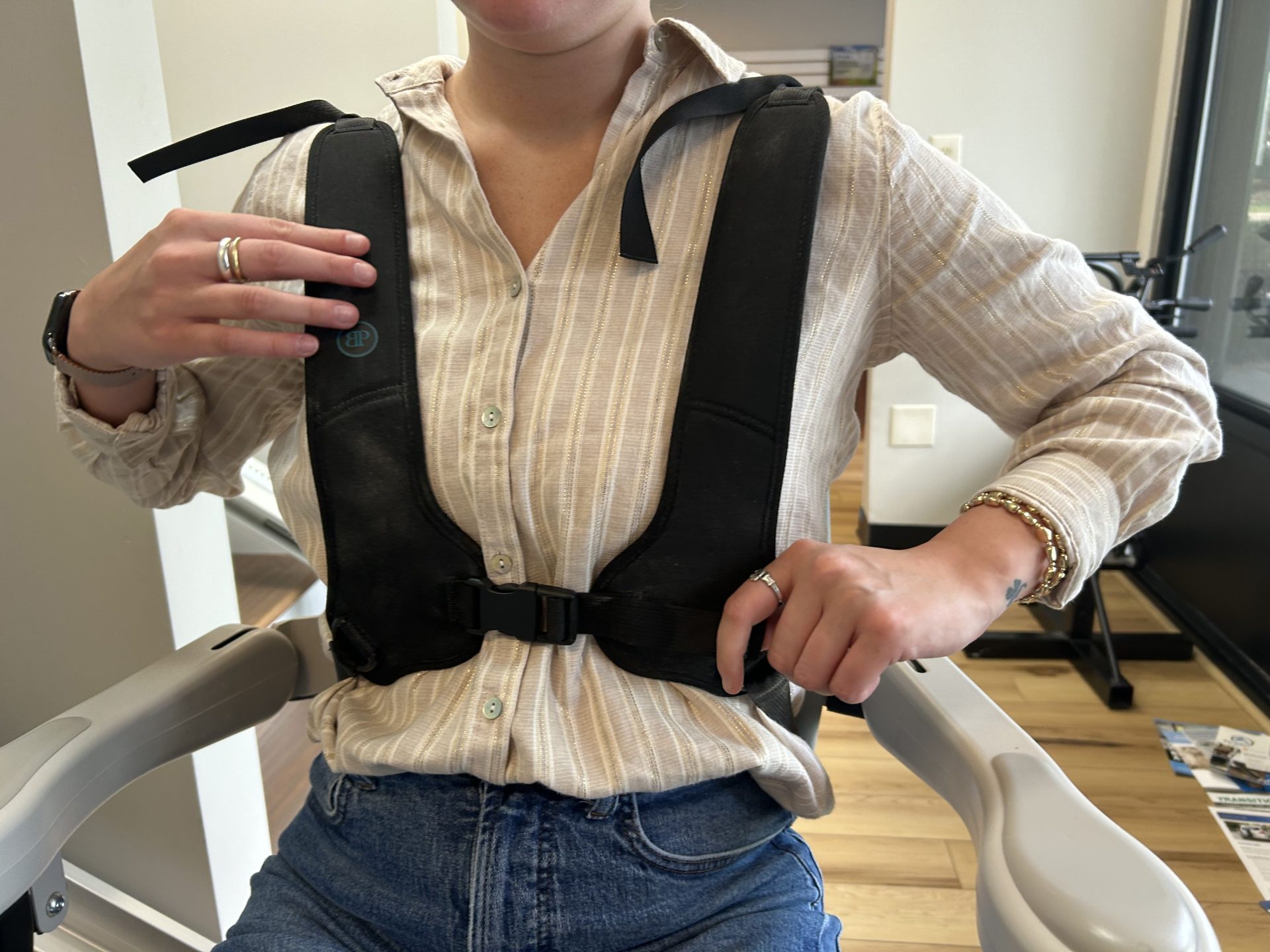 One of our testers sits in the Bruno Elite and shows off the harness seat belt.