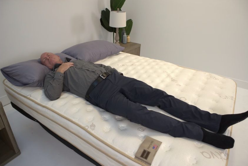 Our tester, who has a history of chronic lower back pain, testing the Saatva Classic mattress