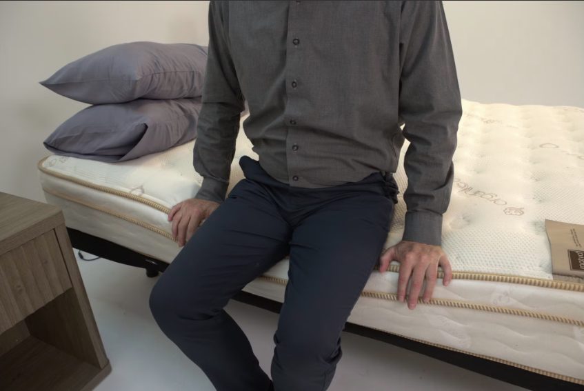 One of our testers, who has a history of lower back pain, testing the edge support on the Saatva Classic mattress.