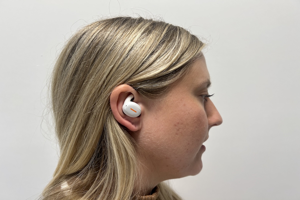 Blonde woman wearing a white Linner Mars hearing aid