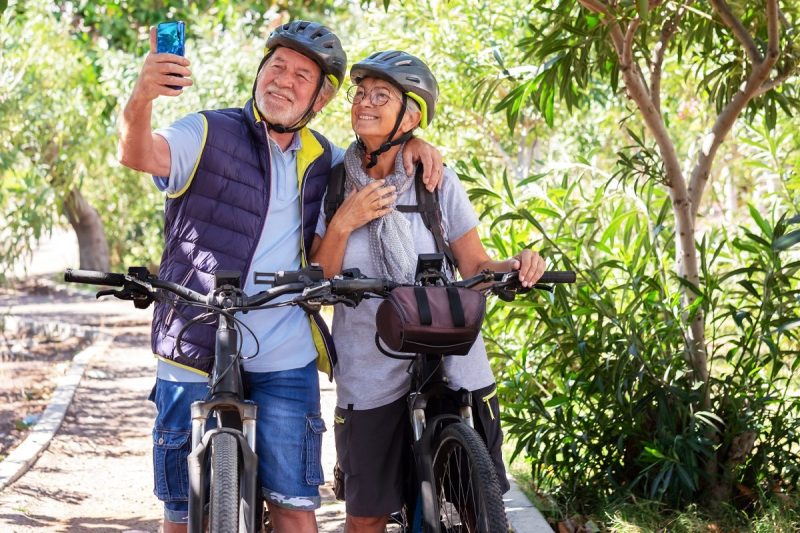 man and woman smile and take a picture while on a bike ride